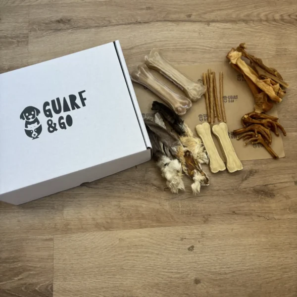 Caja Dental & Mordedor talla mediana abierta vista desde arriba, con orejas de conejo, huesos de colágeno, huesos prensados, palitos trenzados y patas de pollo